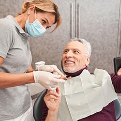 a patient smiling and admiring their dentures